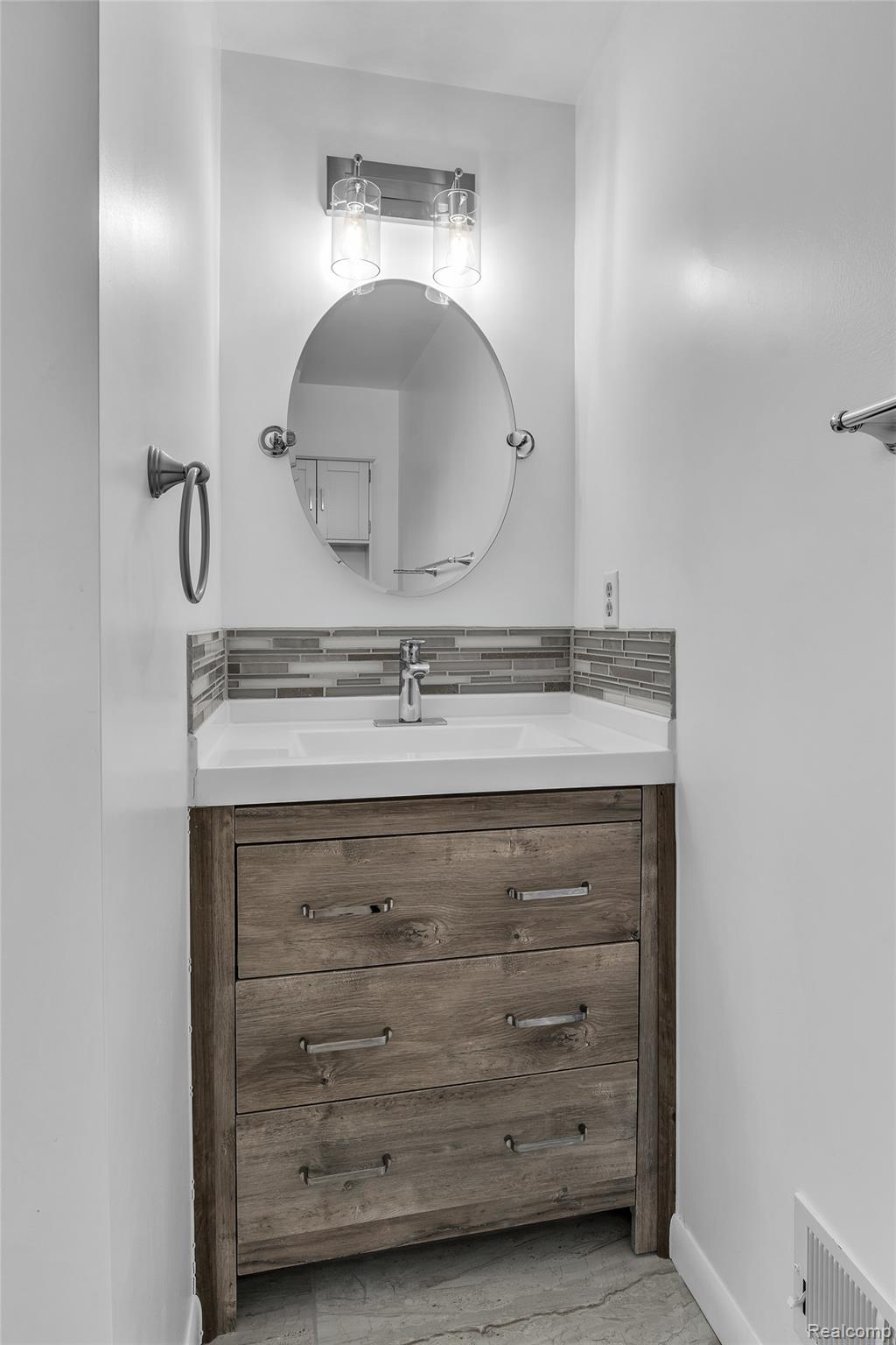 7000 Woonsocket Street Canton, MI 48187 - Photo 46 of 65 Modern vanity featuring wood-finish cabinetry, a white integrated sink, and a mosaic tile backsplash