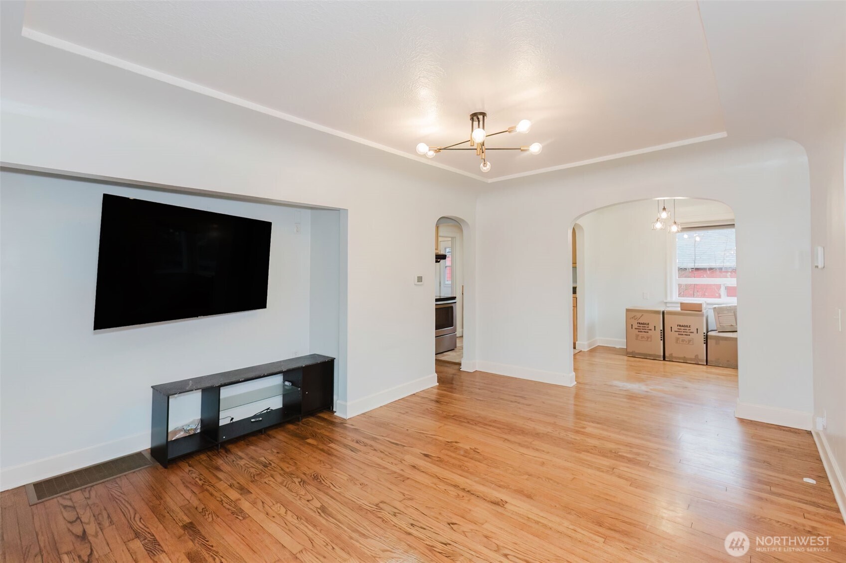 1908 Snyder Avenue Bremerton, WA 98312 - Photo 13 of 35 a view of a livingroom with a flat screen tv wooden floor and a ceiling fan