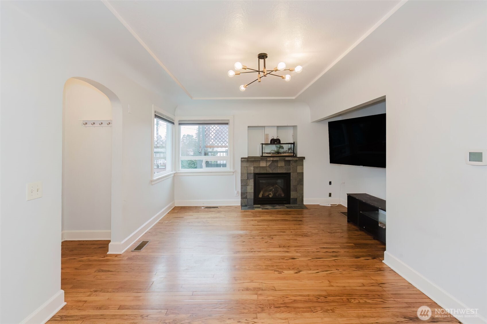 1908 Snyder Avenue Bremerton, WA 98312 - Photo 6 of 35 a view of a livingroom with a flat screen tv wooden floor and a fireplace