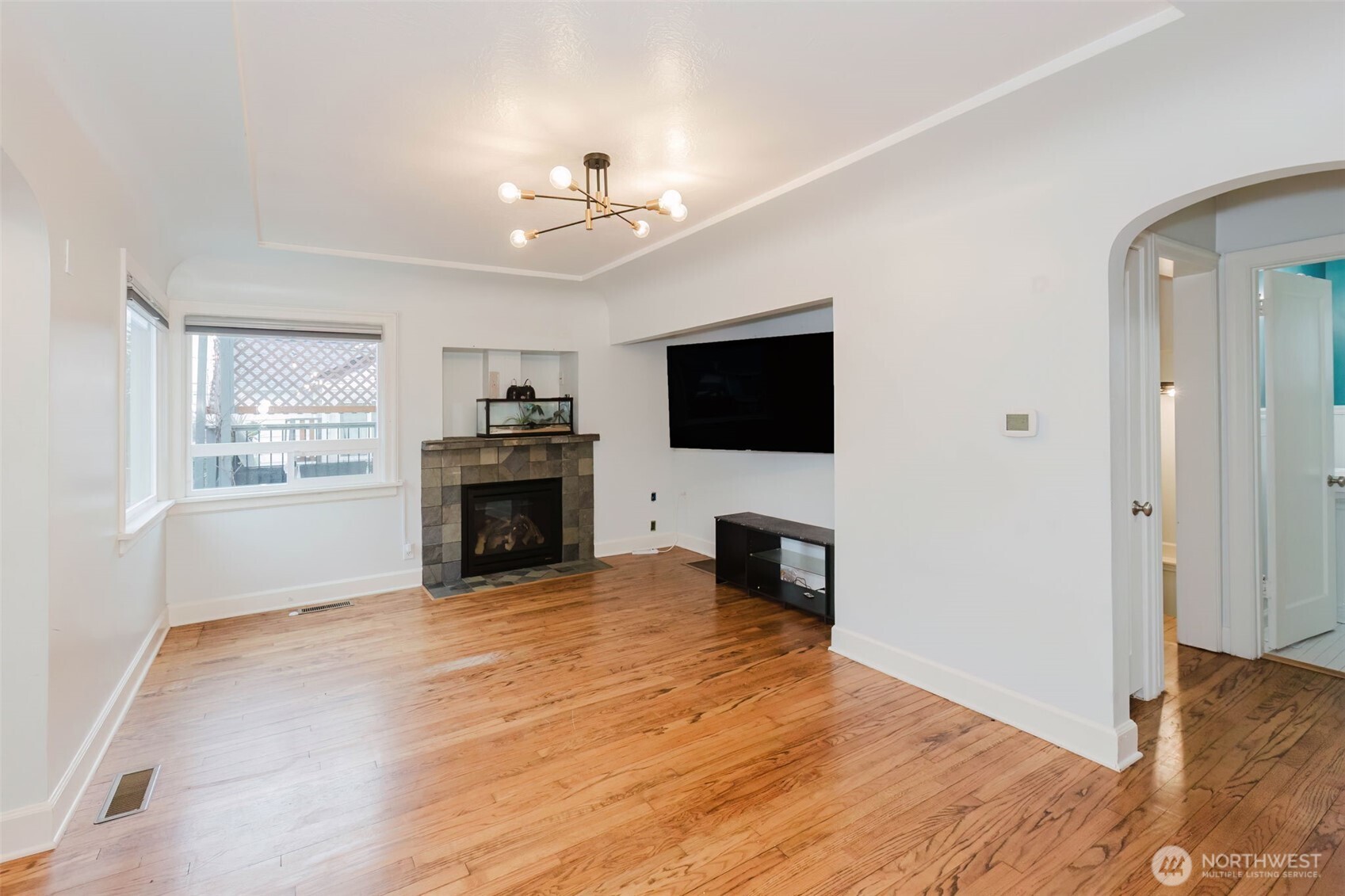 1908 Snyder Avenue Bremerton, WA 98312 - Photo 7 of 35 a view of a livingroom with a fireplace a ceiling fan and windows