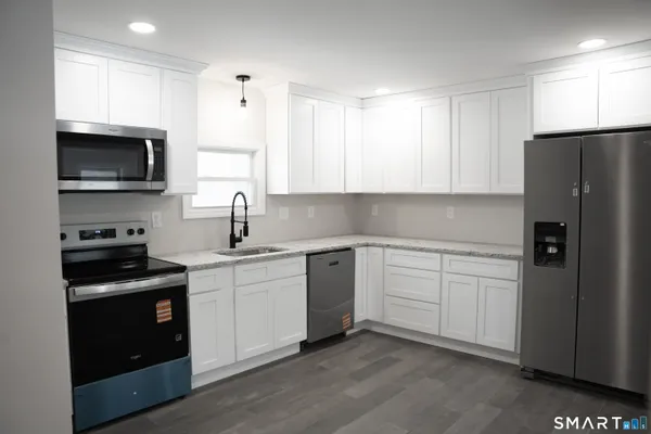 a kitchen with stainless steel appliances a refrigerator sink and microwave