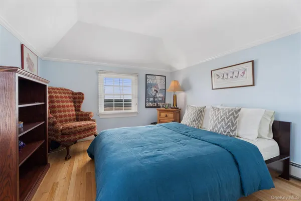 a bedroom with a bed and a lamp on dresser