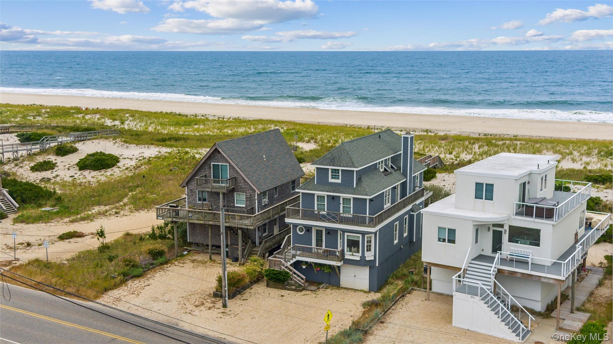 891 Dune Road West Hampton Dunes, NY 11978 - Photo 2 of 34 a view of an ocean with a building in the background