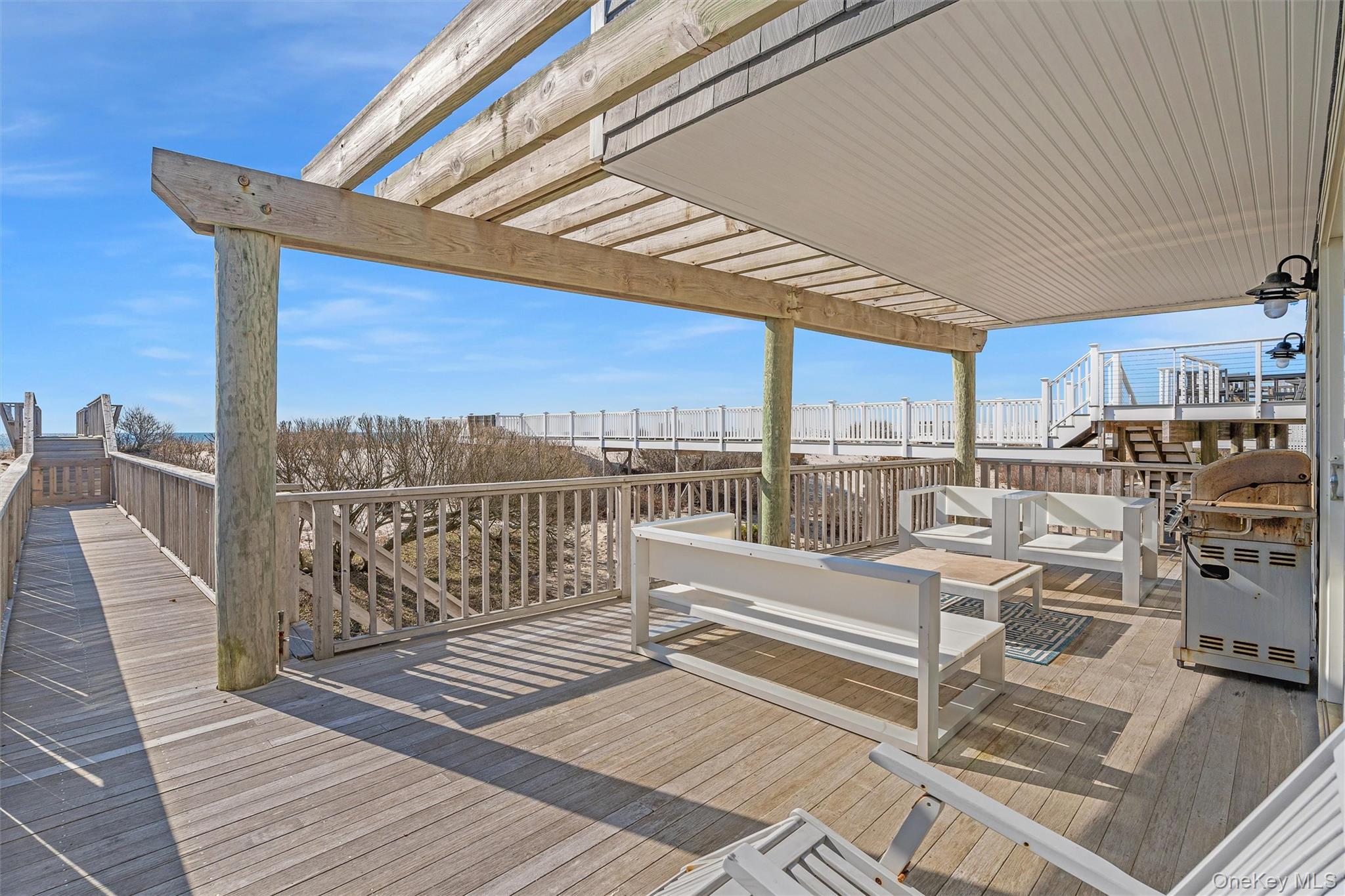 891 Dune Road West Hampton Dunes, NY 11978 - Photo 23 of 34 a view of a balcony with wooden floor and iron stairs