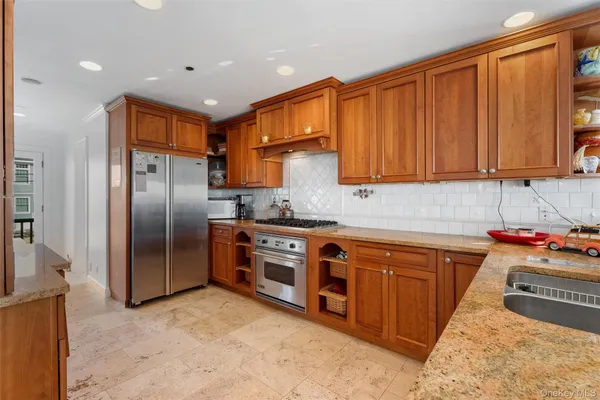 a kitchen with stainless steel appliances granite countertop a refrigerator and a stove