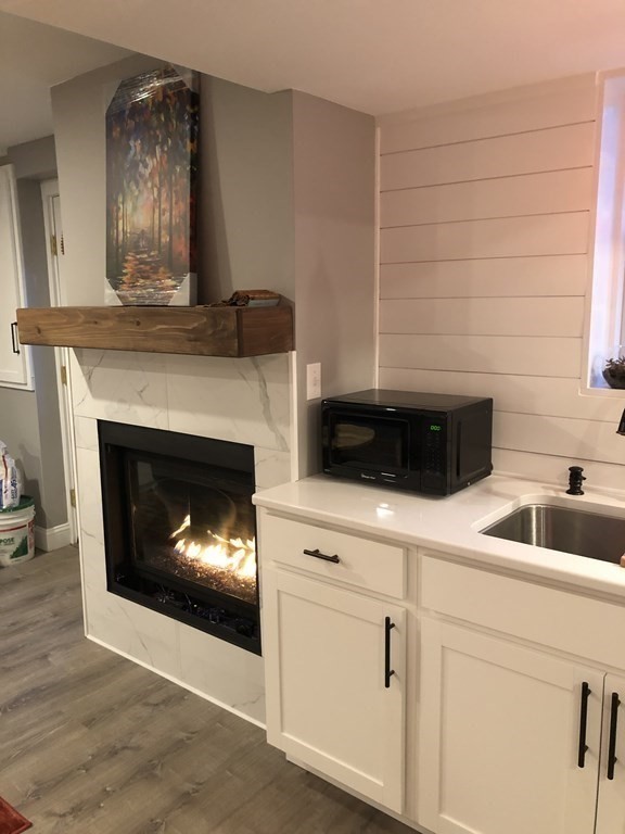 1 Park Road, Unit 1 Sandwich, MA 02644 - Photo 7 of 25 a kitchen with a fireplace and cabinets