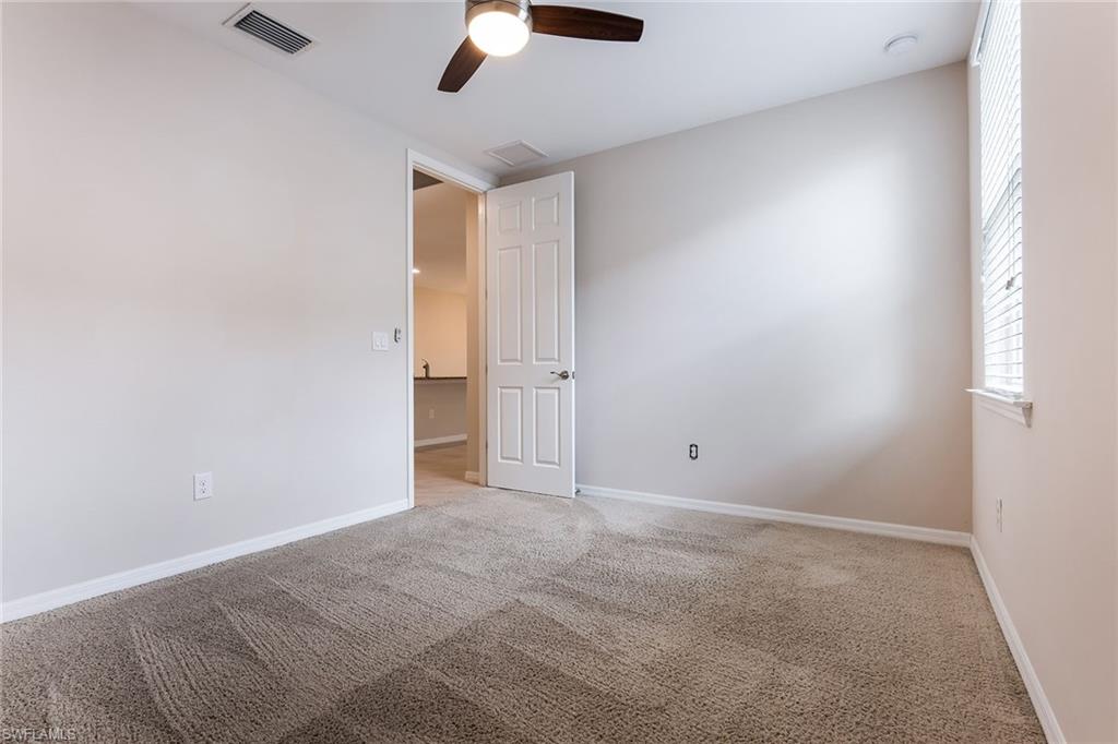 14533 Edgewater Circle Naples, FL 34114 - Photo 11 of 24 an empty room with chandelier fan