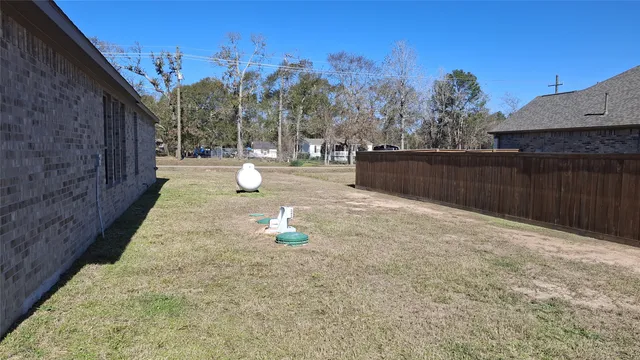 a view of a yard with wooden fence