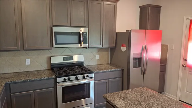 a kitchen with a stove microwave and refrigerator
