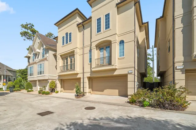 a front view of a multi story residential apartment building with yard