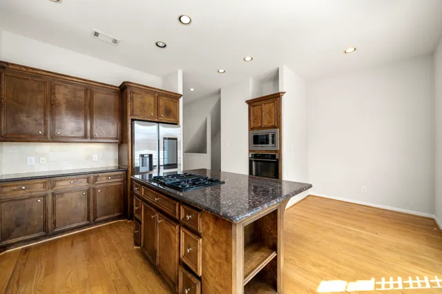 a large kitchen with stainless steel appliances granite countertop a stove and a refrigerator