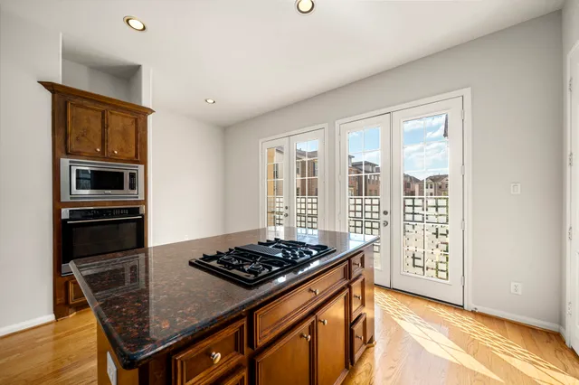 a view of an empty room with wooden floor fireplace and a window