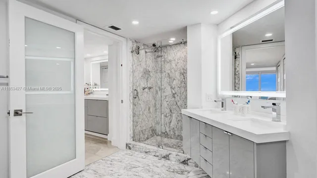 a bathroom with a double vanity sink mirror and shower
