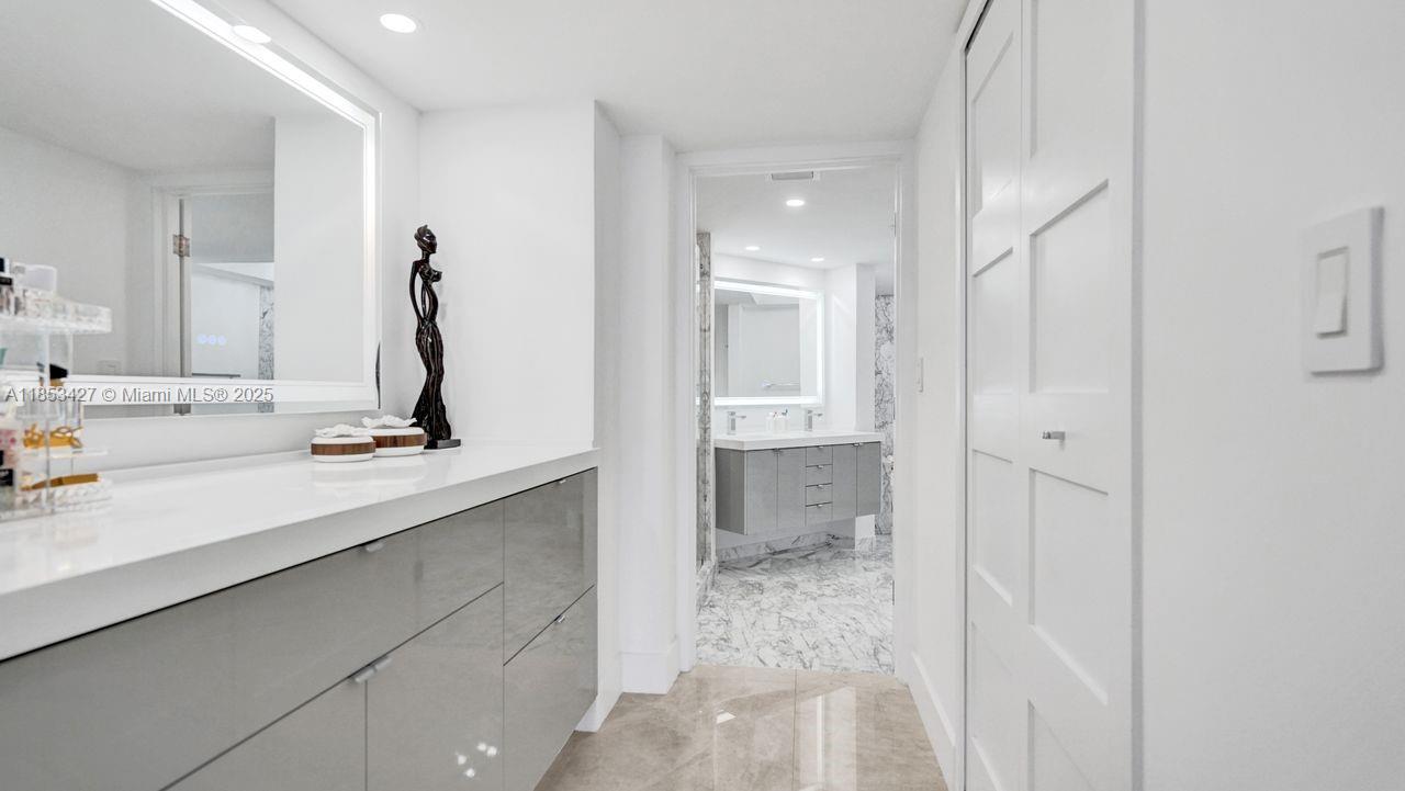 5757 Collins Avenue, Unit 1605 Miami Beach, FL 33140 - Photo 16 of 40 a bathroom with a tub sink and mirror