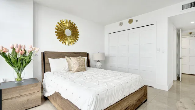 a bedroom with a bed and a potted plant