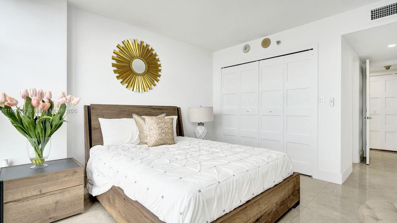 5757 Collins Avenue, Unit 1605 Miami Beach, FL 33140 - Photo 18 of 40 a bedroom with a bed and a potted plant