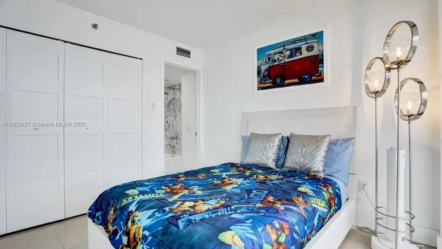 a bedroom with a bed and a painting on the wall