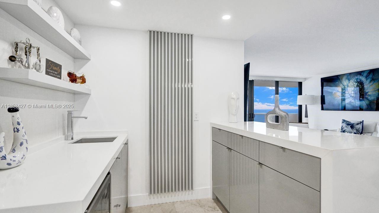 5757 Collins Avenue, Unit 1605 Miami Beach, FL 33140 - Photo 7 of 40 a kitchen with a sink and cabinets
