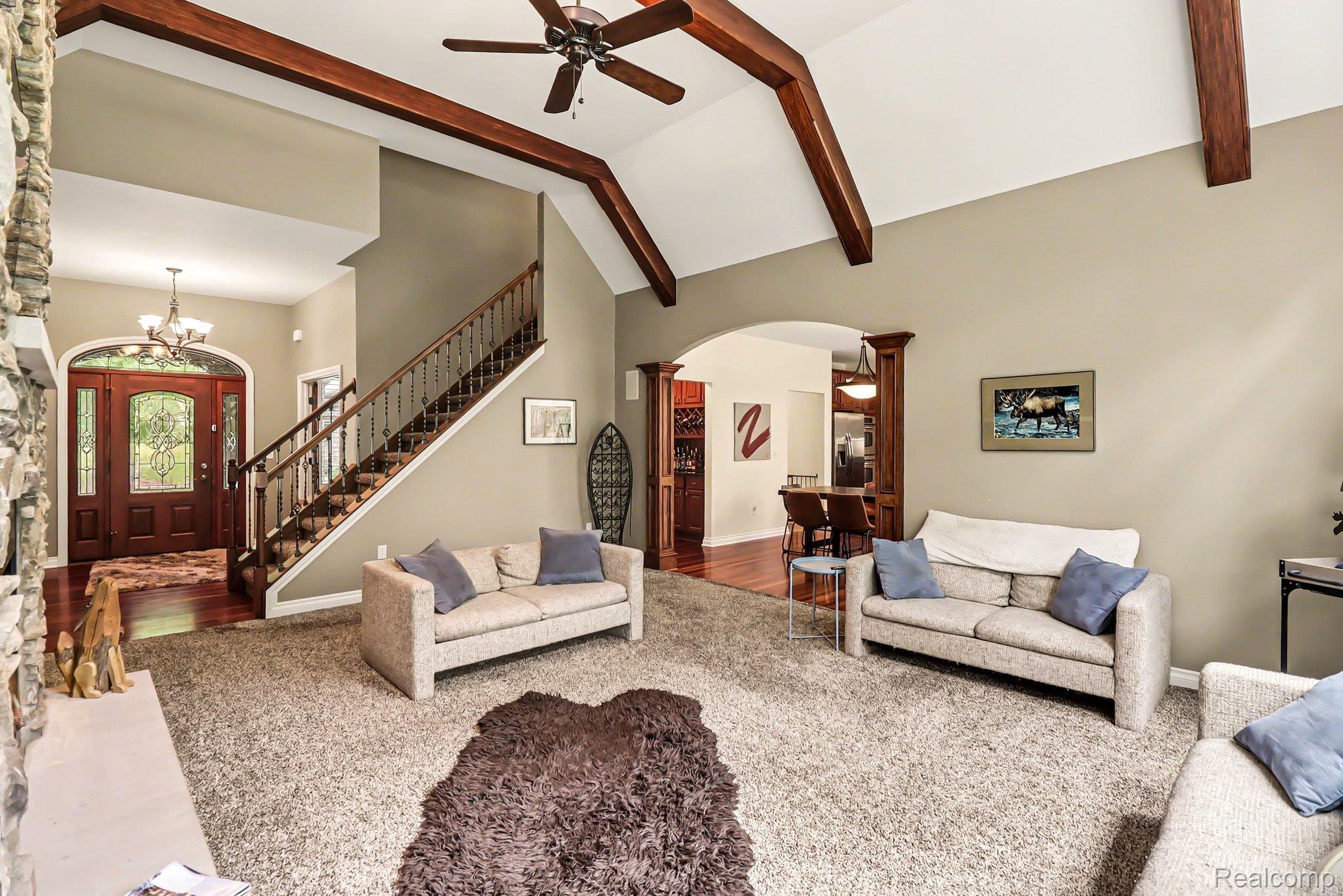 10490 Deer Ridge Trail Holly, MI 48442 - Photo 7 of 56 Vaulted ceiling with exposed wood beams and a ceiling fan