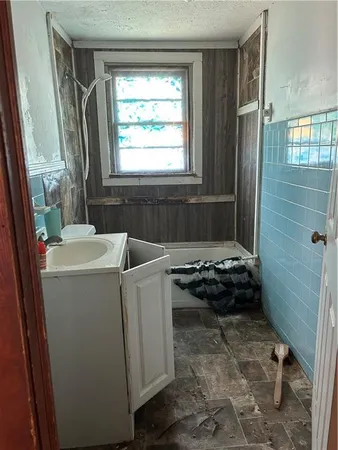 a bathroom with a tub a sink a window and a shower