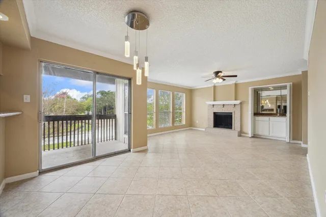 a view of empty room with floor to ceiling window and fireplace