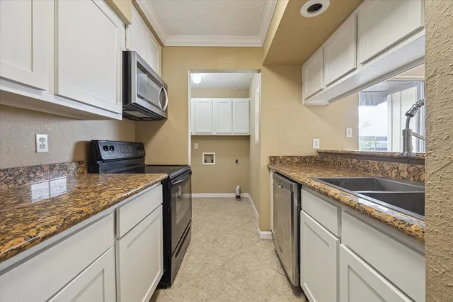 a kitchen with stainless steel appliances granite countertop a sink and a stove