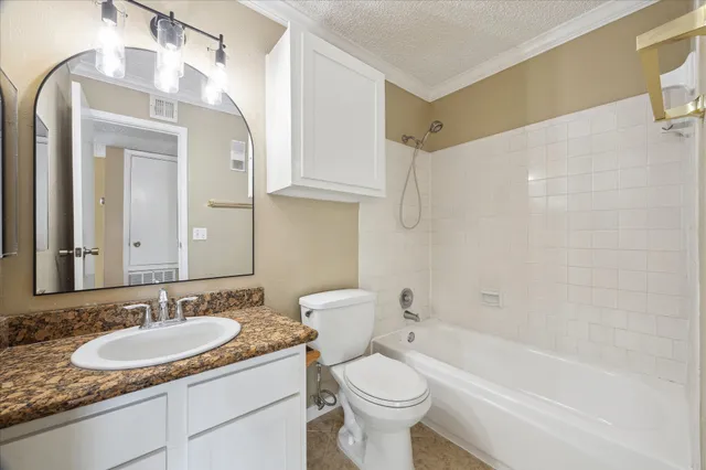 a bathroom with a granite countertop sink mirror toilet and bathtub
