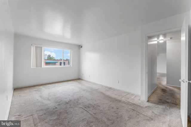 an empty room with windows and closet