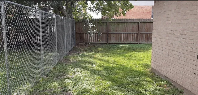 a view of a backyard with wooden fence