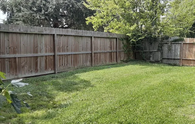 a view of backyard with wooden fences