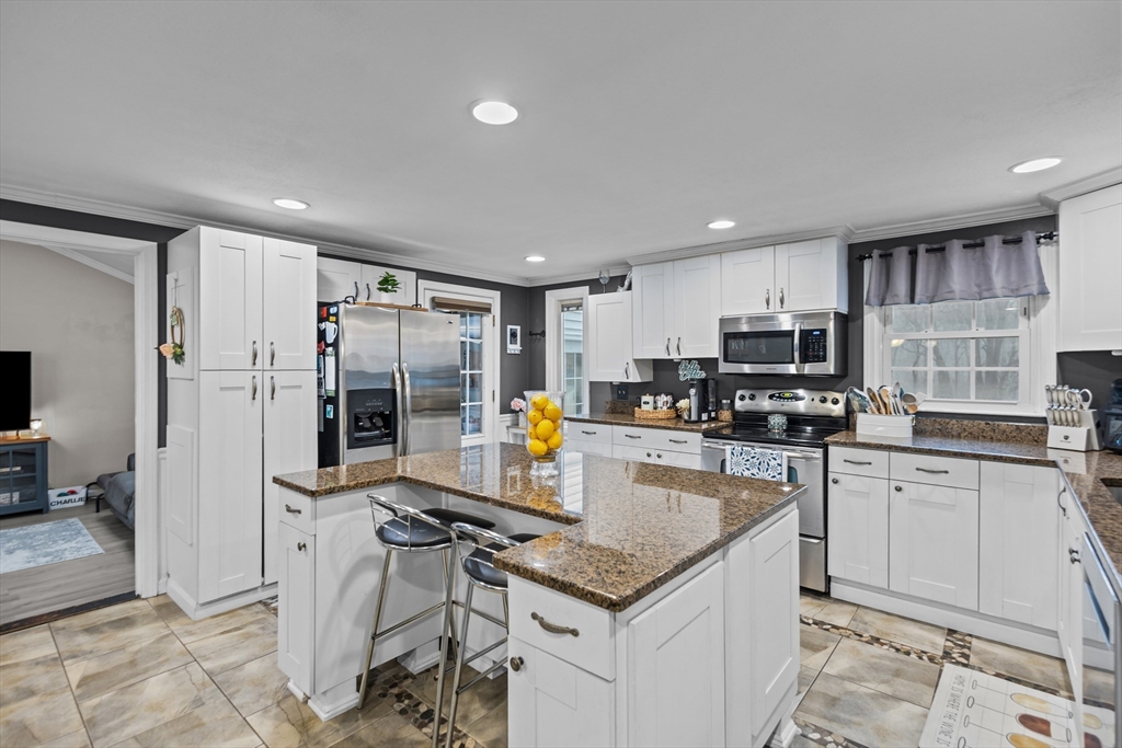 14 Mine Brook Road Rehoboth, MA 02769 - Photo 4 of 40 a kitchen with stainless steel appliances granite countertop a stove top oven a sink dishwasher a dining table and chairs with wooden floor