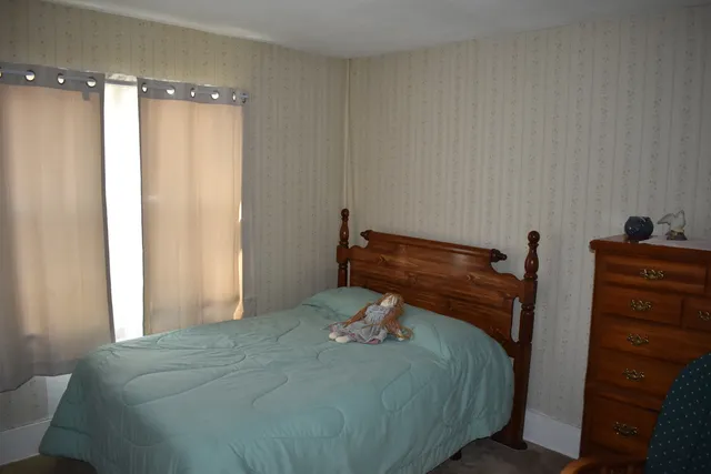 a bed sitting in a bedroom next to a window