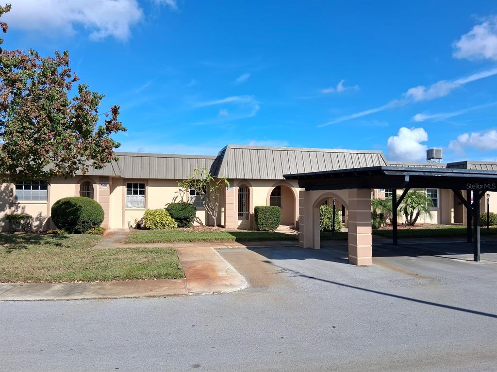 a view of a house with backyard and sitting area