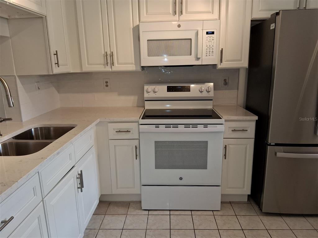 4326 Summersun Drive New Port Richey, FL 34652 - Photo 8 of 28 a kitchen with white cabinets and white appliances