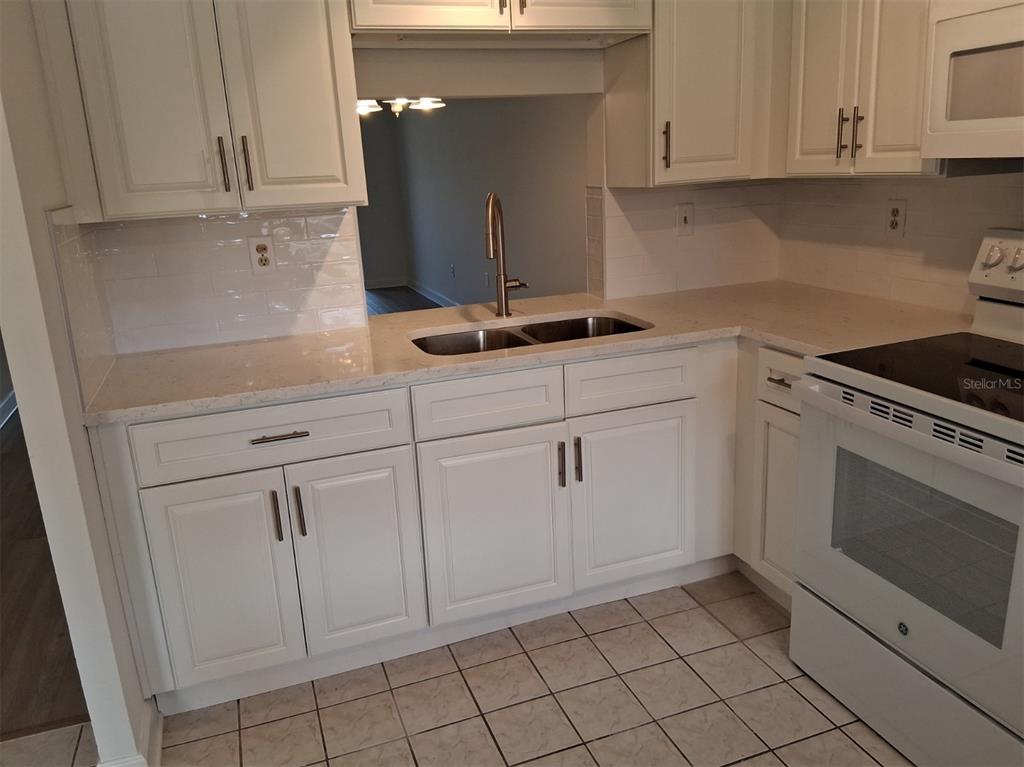4326 Summersun Drive New Port Richey, FL 34652 - Photo 9 of 28 a kitchen with white cabinets and appliances