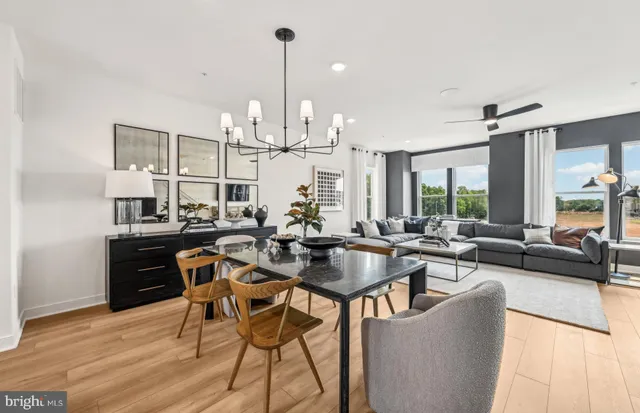 a view of a dining room and livingroom with furniture wooden floor a chandelier