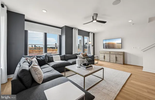 a living room with furniture and a view of kitchen