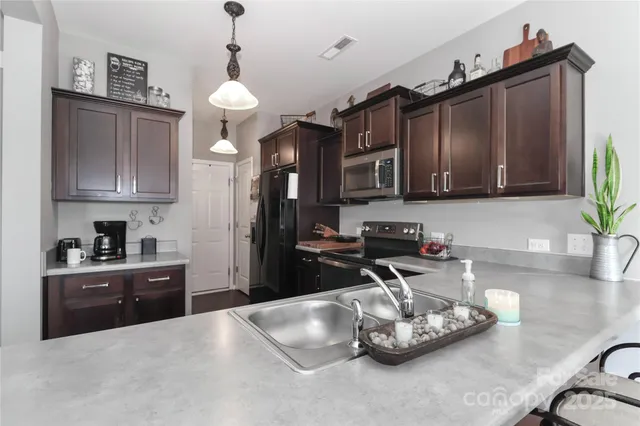 a kitchen with granite countertop a sink cabinets and stainless steel appliances