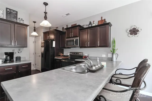 a kitchen with stainless steel appliances granite countertop a stove microwave and refrigerator