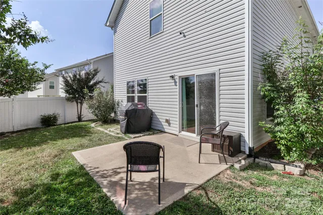 a view of a house with backyard and trees