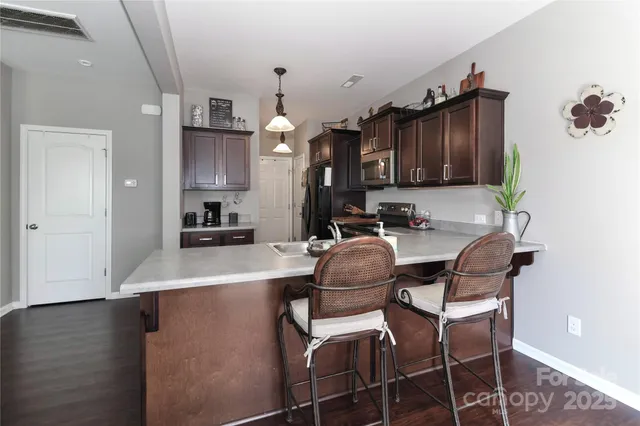 a kitchen with sink refrigerator dining table and chairs