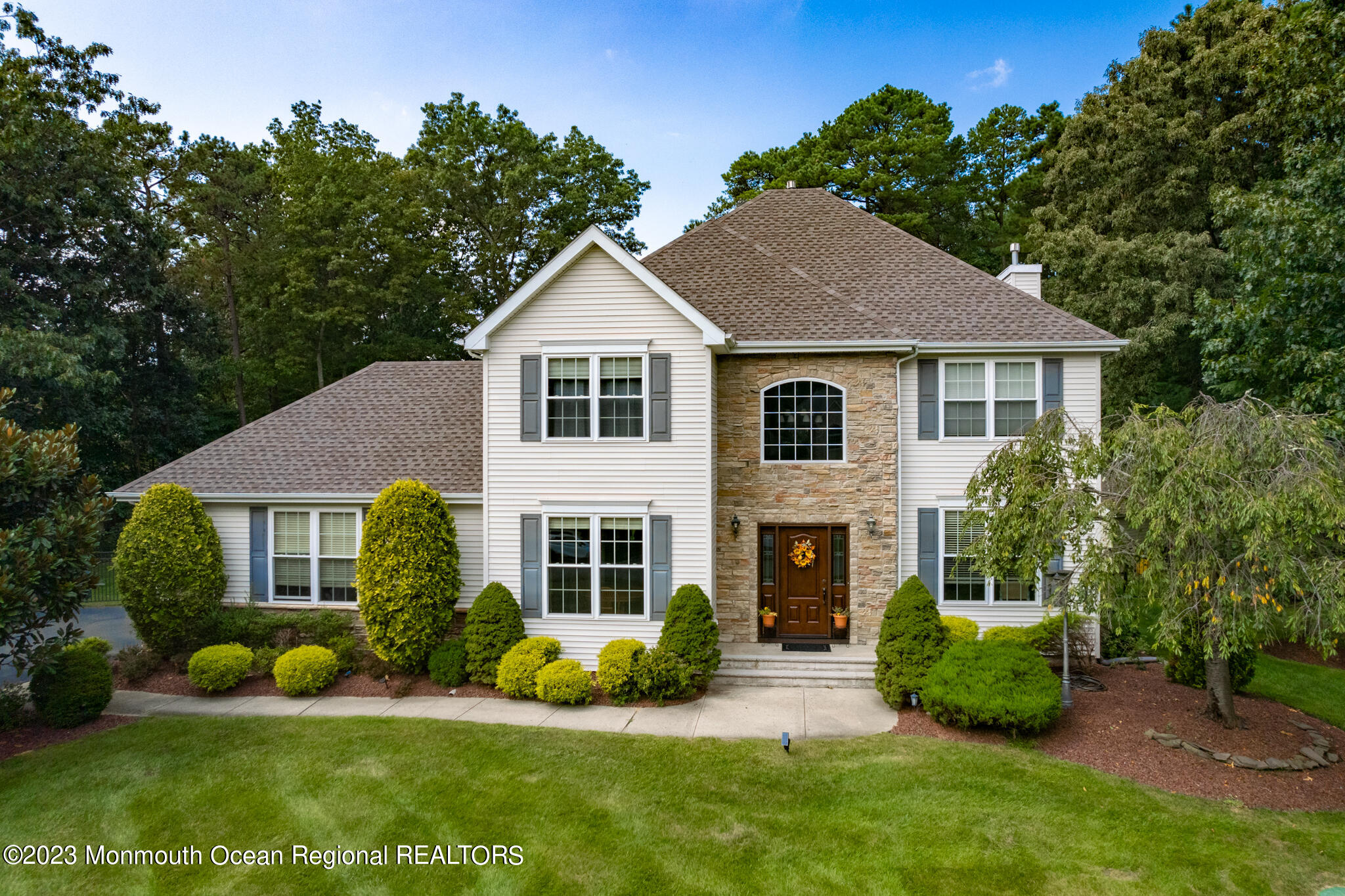 a front view of a house with a yard and potted plants
