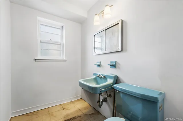 a bathroom with a sink a toilet and a window