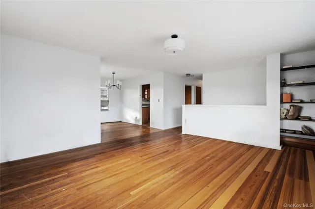 a view of empty room with wooden floor and cabinets
