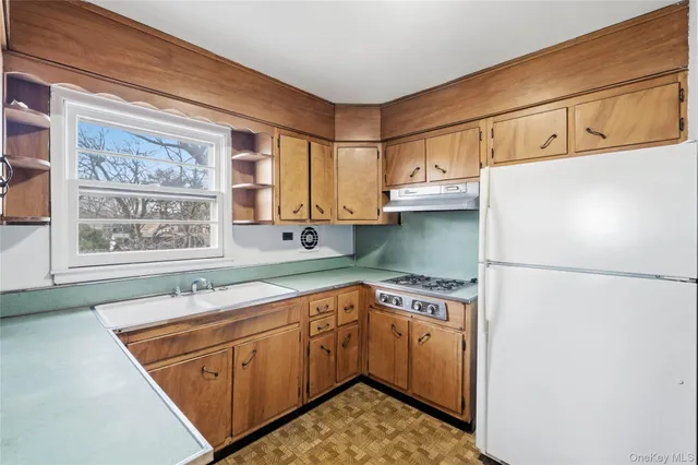 a kitchen with a sink cabinets appliances and a window