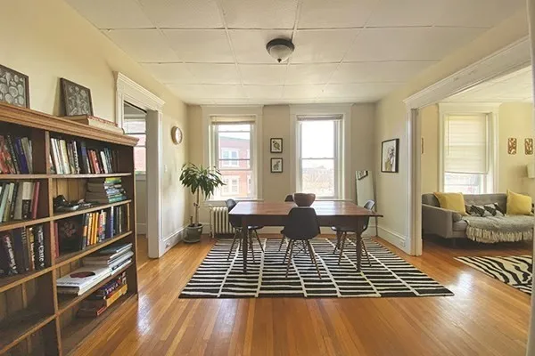 a living room with furniture and a book shelf