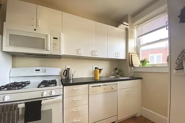 a kitchen with white cabinets and appliances