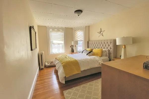 a bedroom with a bed and wooden floor