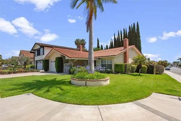 a front view of a house with a garden and plants