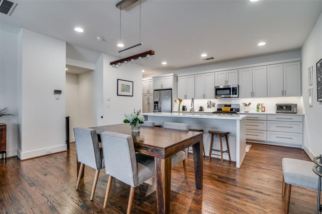 5602 Lindell Avenue, Unit B Dallas, TX 75206 - Photo 11 of 29 a kitchen with stainless steel appliances granite countertop a stove top oven a refrigerator a sink and white cabinets with wooden floor